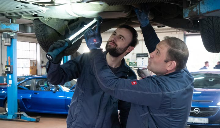 Kfz-Mechaniker ckecken Auto auf der Hebebühne